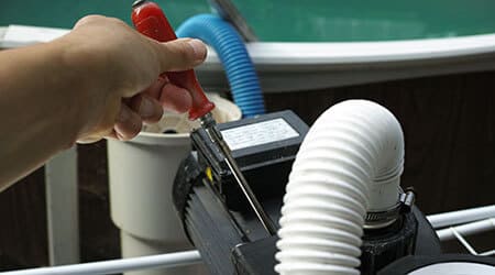A service man is repairing pool equipment