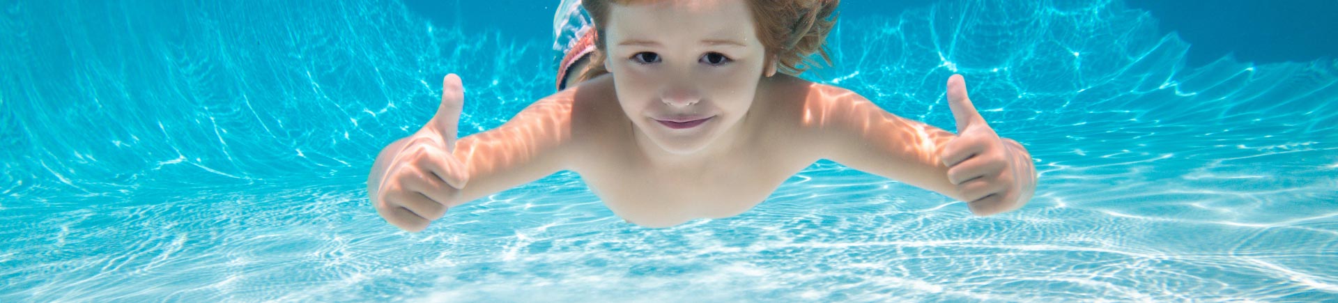 Child swimming underwater with thumbs up