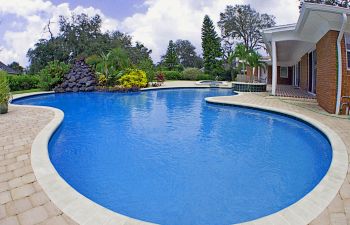Large outddor swimming pool at a suburbian home.