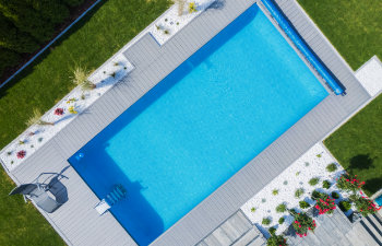 perfectly maintained outdoor swimming pool surrounded by green lawn