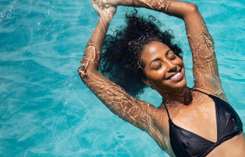 beautiful woman in black bikini relaxing in the pool