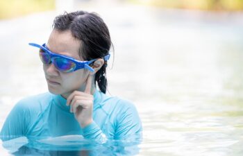 Stressed asian girl had tinnitus,problem with water entering the ear canal while swimming,female people cleaning ears after diving in swimming pool,otitis externa,swimmer's ear,health care concept